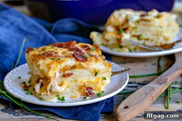 A generous portion of rich, cheesy scalloped potatoes with visible bacon and onion, served on a white plate, emphasizing its comforting appeal.
