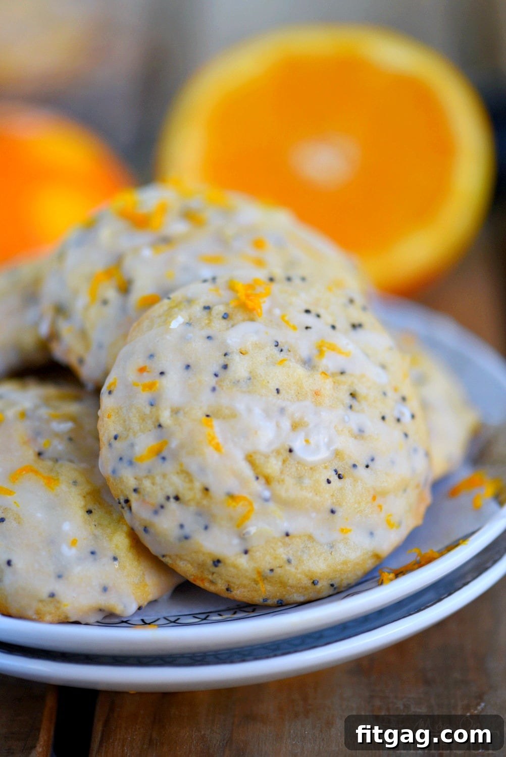 These easy Glazed Orange Poppy Seed Cookies are bursting with orange flavor! So soft and tender, these cookies will quickly become a new favorite! Bonus: no chill time needed! // Mom On Timeout #cookies #orange #poppyseed #easy #baking #dessert orange poppy seed cookies with orange glaze stacked on plate