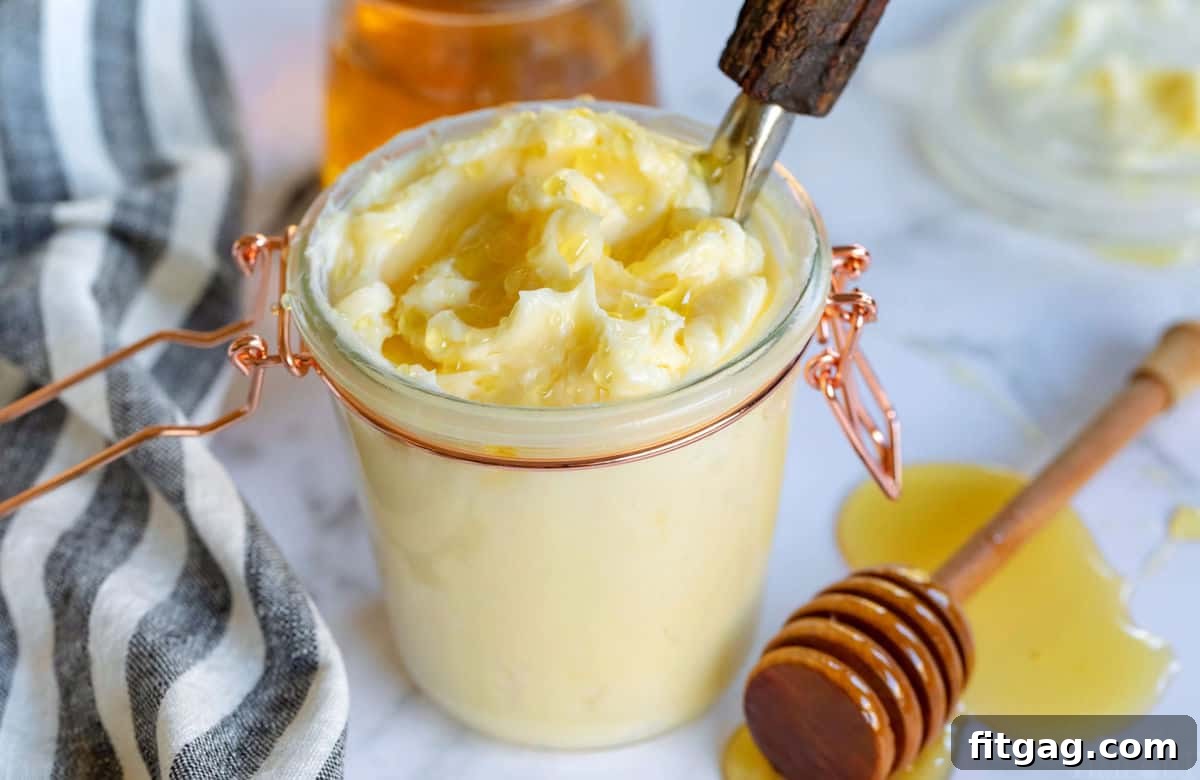 Golden Honey Butter Delight 2 Easy honey butter recipe presented in a rustic glass jar, accompanied by a black and white striped towel, highlighting its homemade charm.