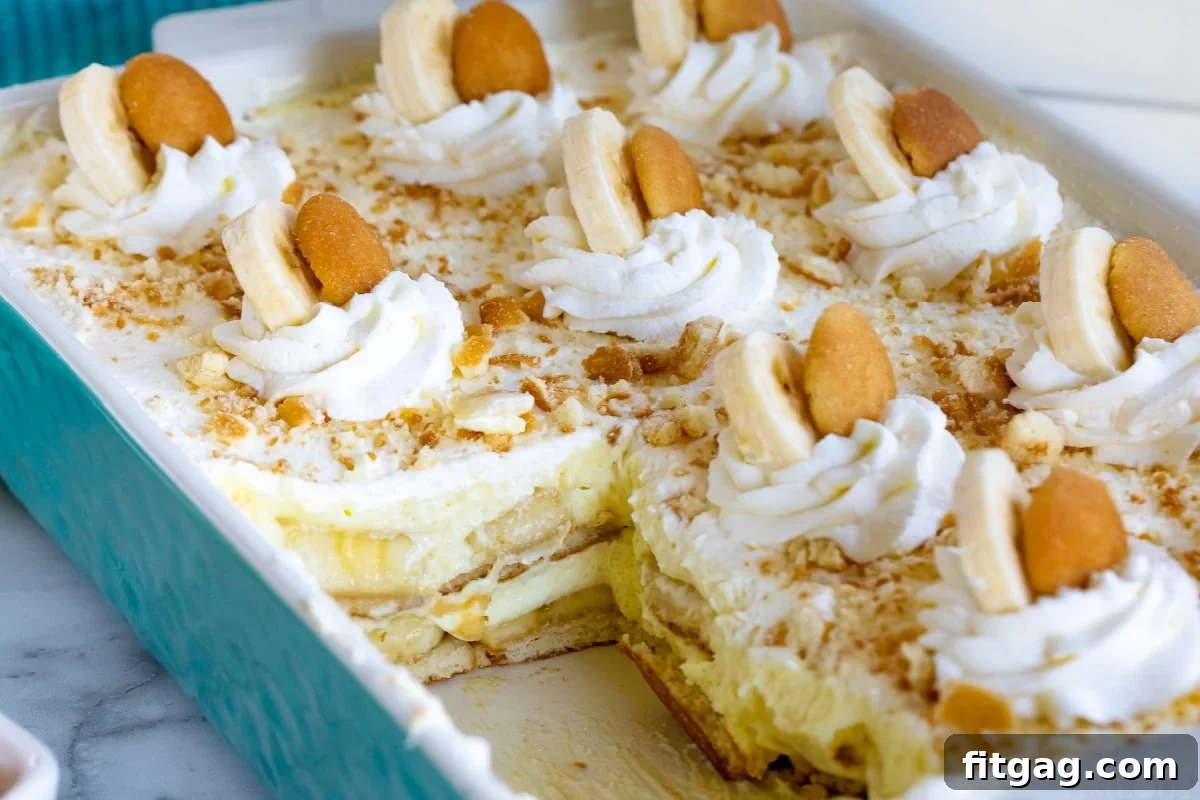Teal casserole dish with banana pudding recipe in it with a few servings removed.