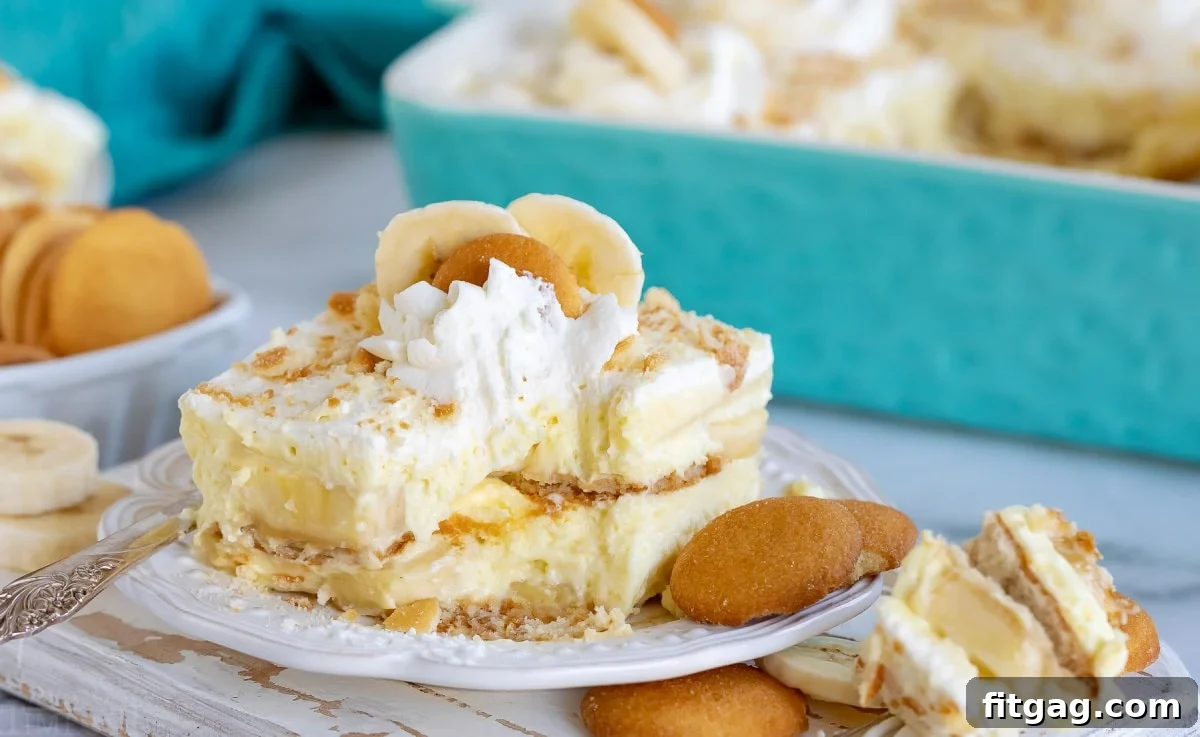 Banana pudding recipe sitting on white plate with bite removed with fork still on plate.