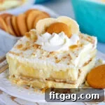 The best banana pudding recipe served on a white plate garnished with whipped cream and Nilla wafers.