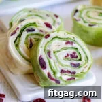 turkey pinwheels recipe with dried cranberries on small white cutting board squared