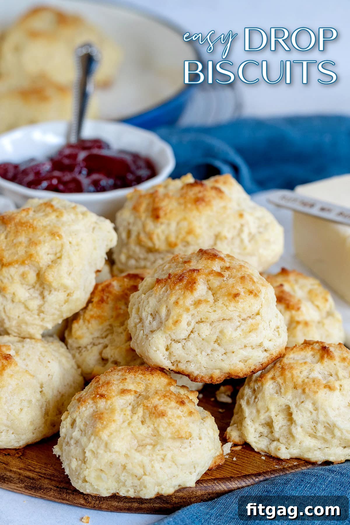 A stack of golden brown, fluffy drop biscuits on a rustic wooden board, ready to be enjoyed.