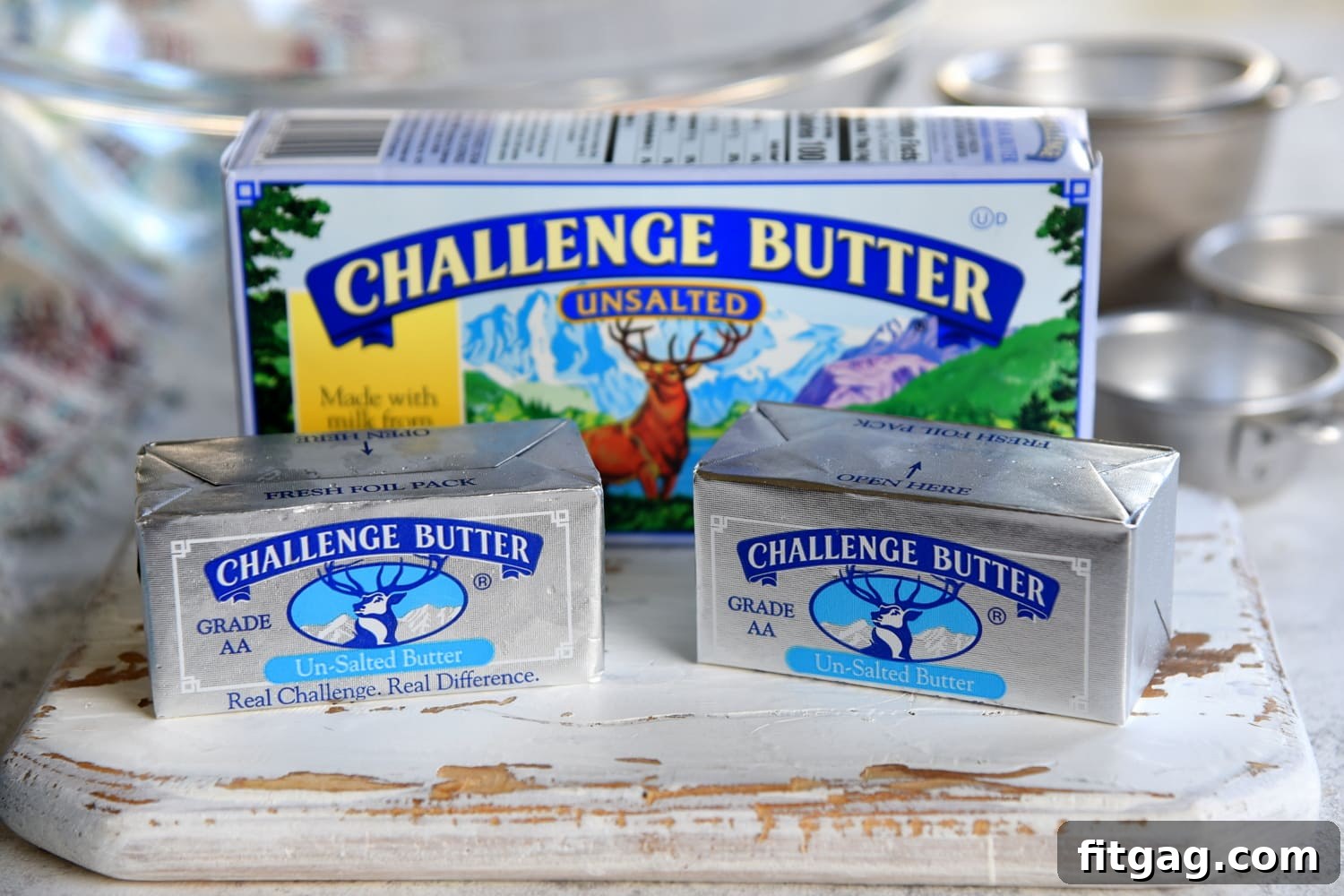 A stick of Challenge unsalted butter resting on a pristine white cutting board, ready for baking.