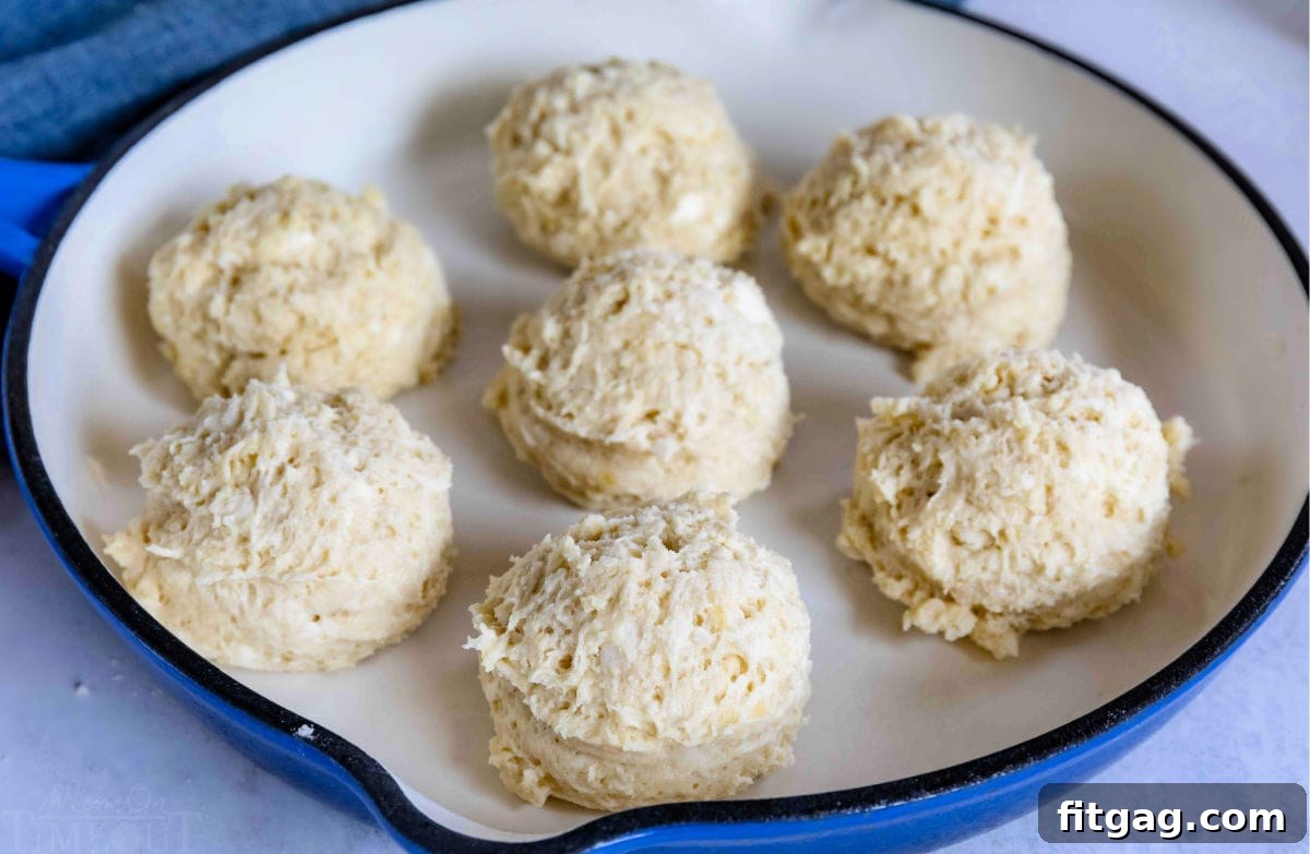 Raw drop biscuit dough scooped into a cast iron skillet, ready for baking.