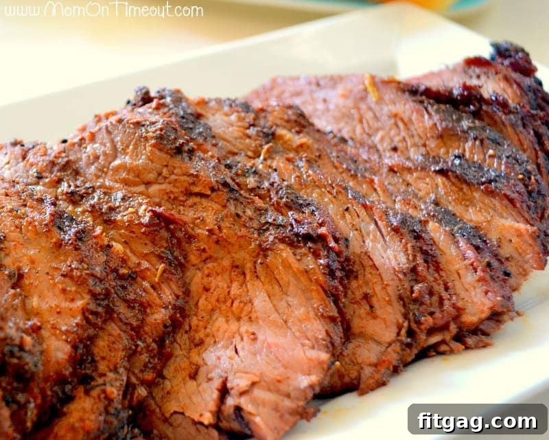 Perfectly sliced beef tri-tip roast resting on a white plate, showcasing its juicy interior and crispy exterior.