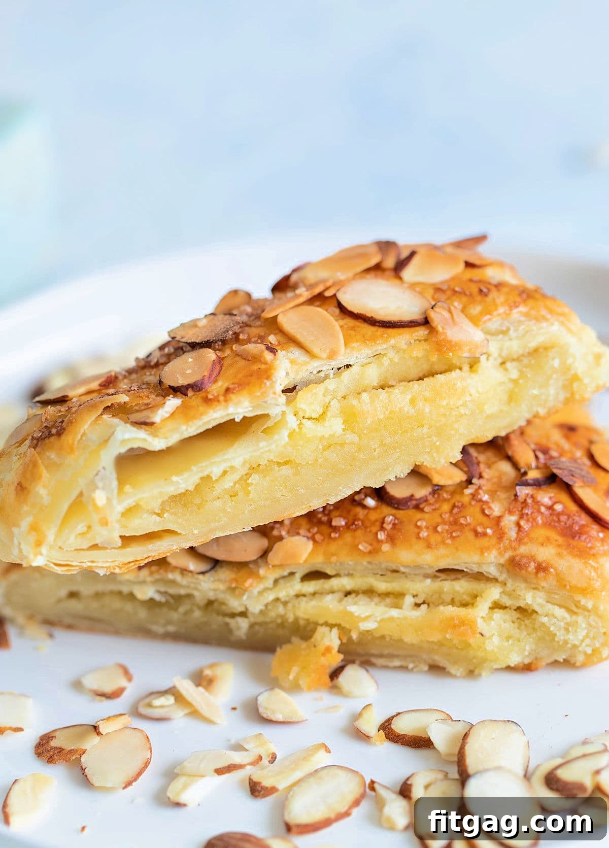 Effortless Almond Bear Claws 3 two pieces of Almond Bear Claw pastry on white plate garnished with sliced almonds, ready for breakfast or brunch