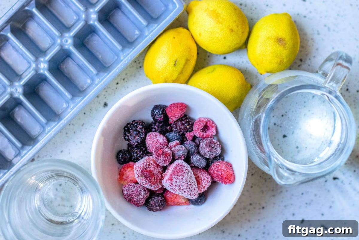 All the essential ingredients for berry lemonade laid out on a kitchen countertop: fresh lemons, frozen mixed berries, and a bottle of cane syrup.