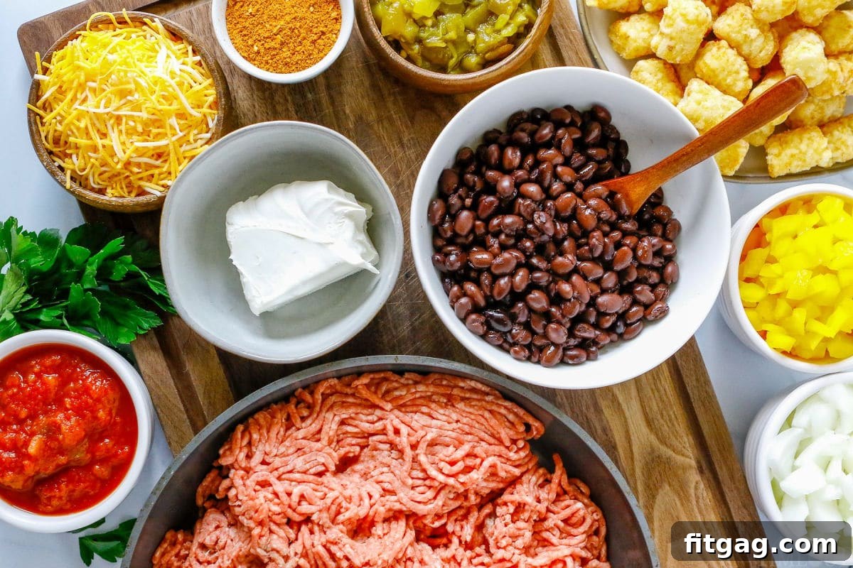 Fiesta Tater Tot Bake 4 Individual ingredients for Taco Tater Tot Casserole, measured and ready in separate bowls on a wooden surface.