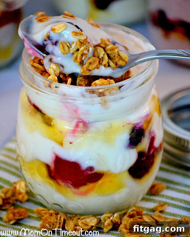Hand adding crunchy granola to a ready-made honey vanilla parfait