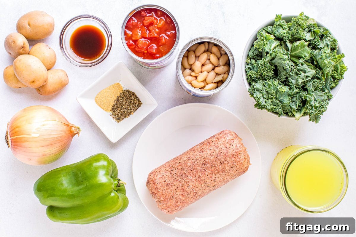 All the fresh ingredients for sausage kale soup, prepped and ready for cooking on a white surface.