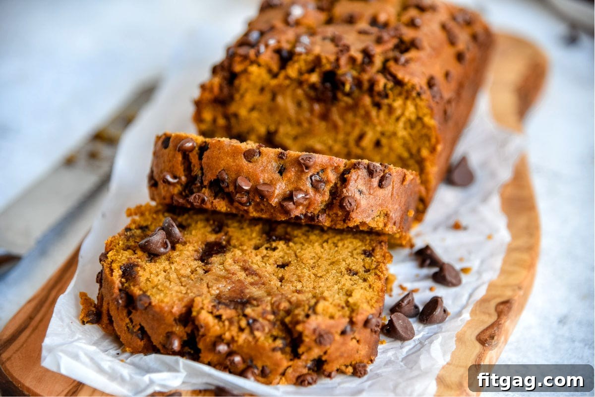 pumpkin bread loaf on cutting board with two slices cut off