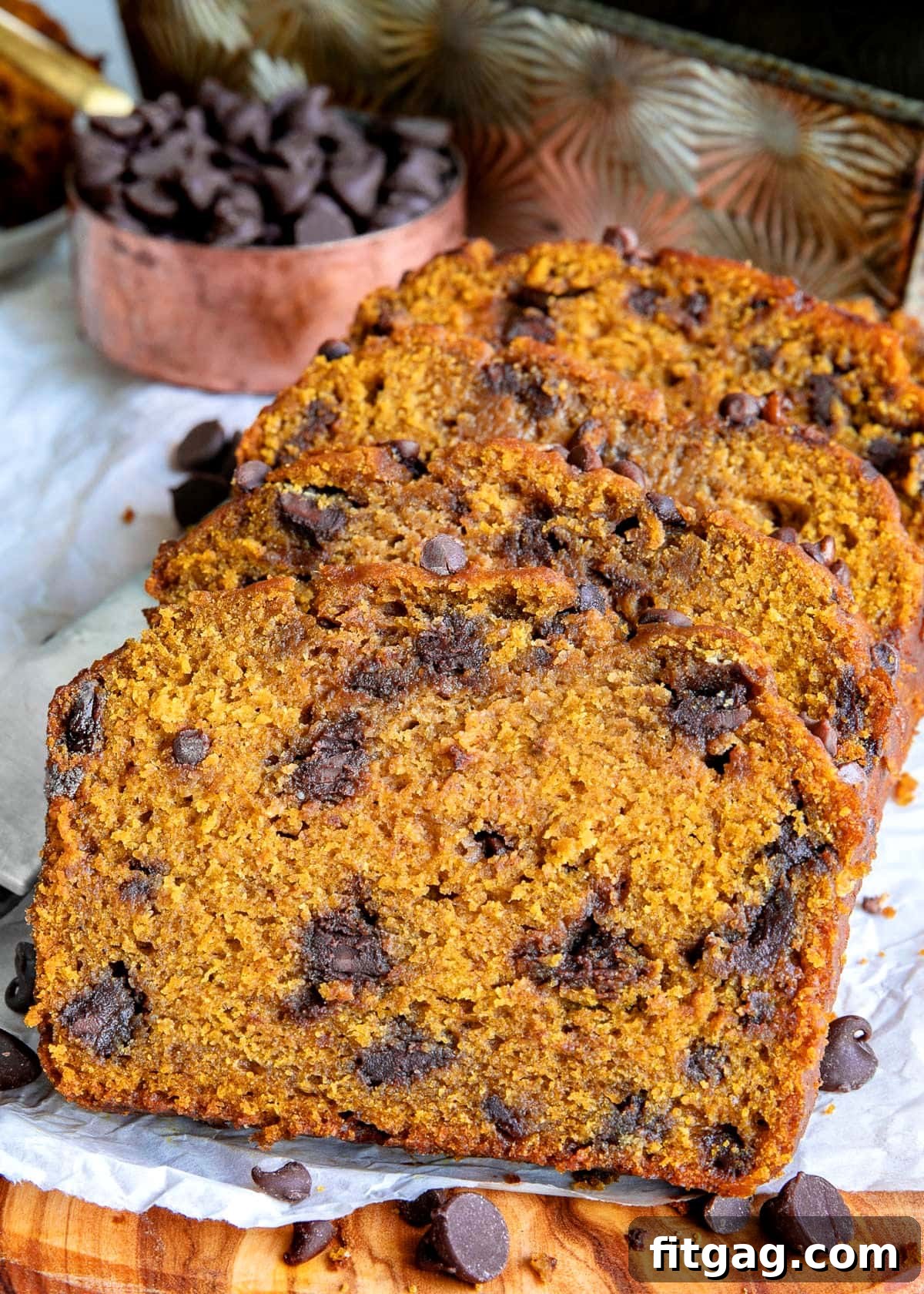 three slices of pumpkin chocolate chip bread laying on each either on a piece of parchment