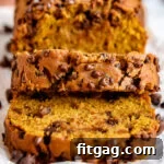 pumpkin bread loaf on cutting board with two slices cut off