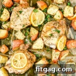 A delicious Greek chicken recipe, complete with roasted potatoes and lemons, prepared on a sheet pan, ready to serve.