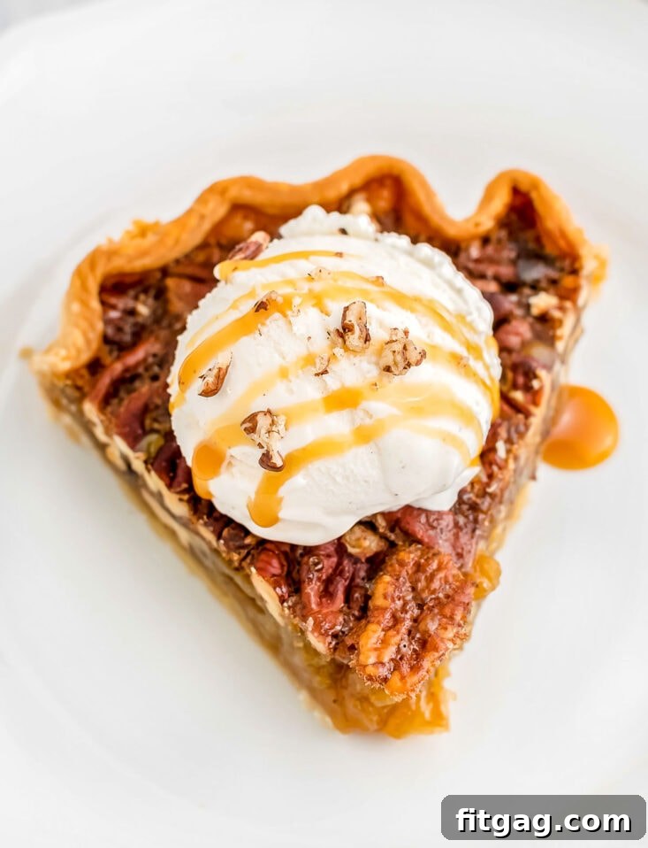 Decadent Maple Pecan Pie 3 A generous slice of Maple Pecan Pie elegantly presented on a white plate, generously topped with a scoop of vanilla ice cream and a luscious caramel drizzle.