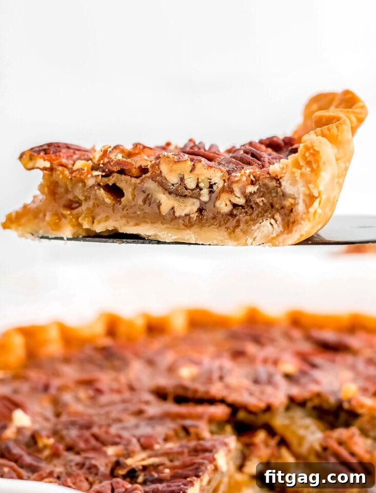 Decadent Maple Pecan Pie 5 A delectable slice of Maple Pecan Pie, perfectly set and showcasing its rich, gooey filling with abundant pecans, ready to be enjoyed.