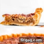 A tempting slice of Maple Pecan Pie, perfectly golden and nutty, a true holiday delight.
