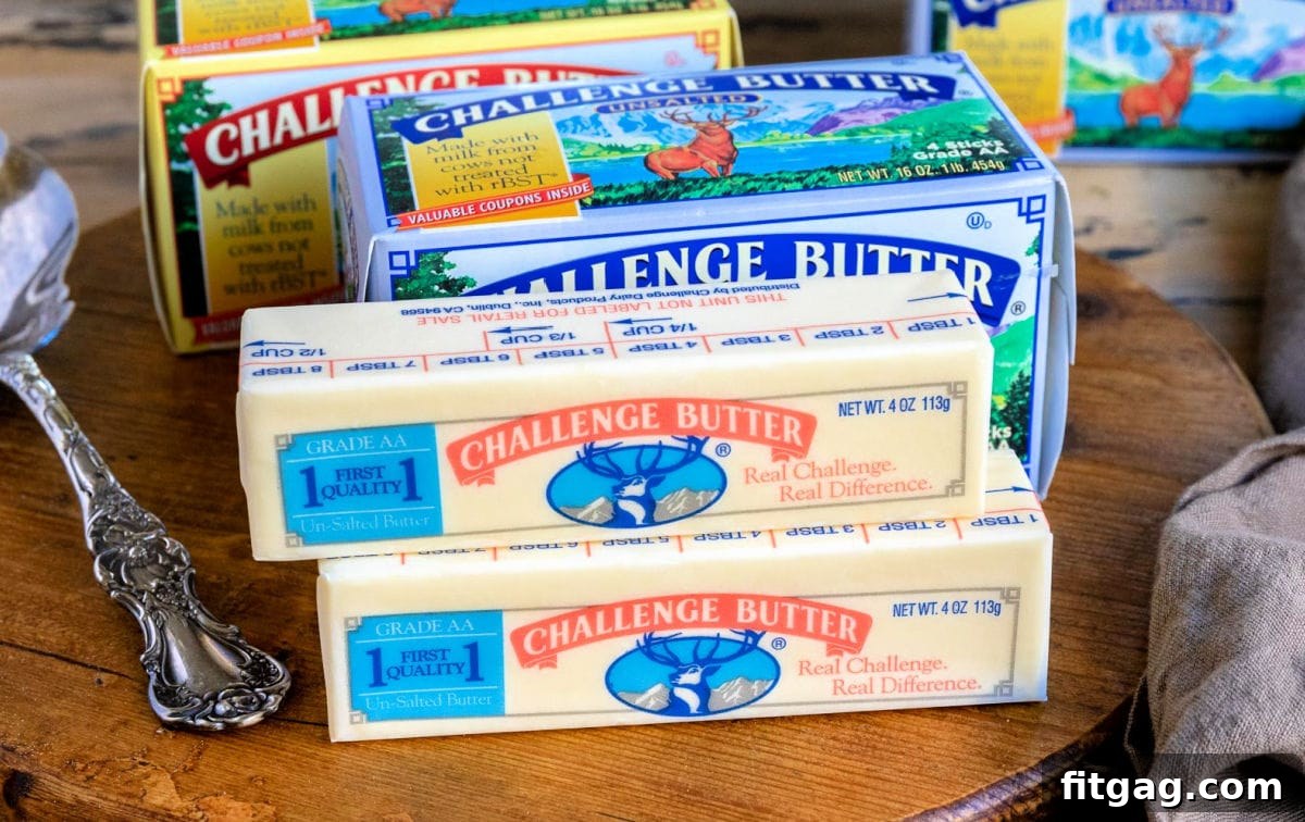 Several sticks of Challenge Butter, unwrapped and neatly arranged on a wooden board, showcasing a key ingredient for the recipe.