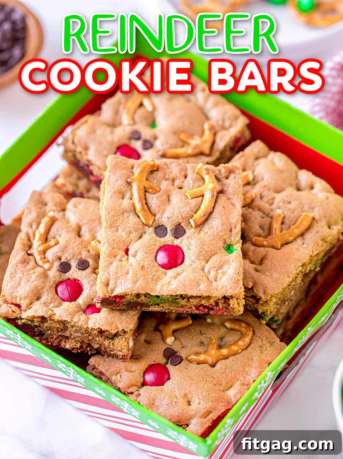 Magical Reindeer Cookie Bars 2 Stacked Reindeer Cookie Bars in a festive red and green Christmas box, adorned with decorative holiday elements, perfect for gifting or a dessert display.