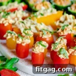 close up of stuffed hummus veggies topped with fresh herbs