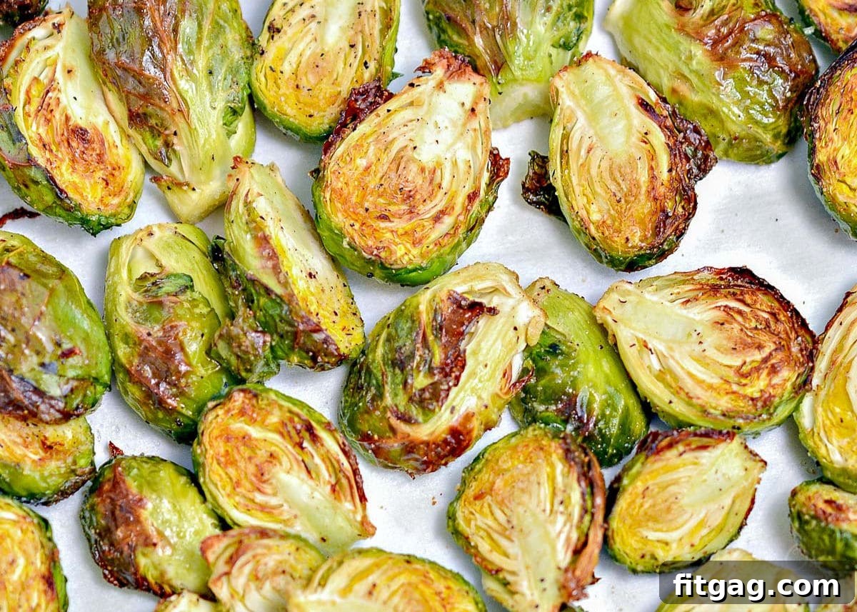 Golden, crispy Brussels sprouts cooked in an air fryer, spread in a single layer in the basket.