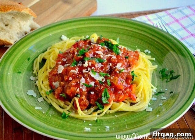 A close-up of a serving of Slow Cooker Spaghetti, garnished with fresh herbs.