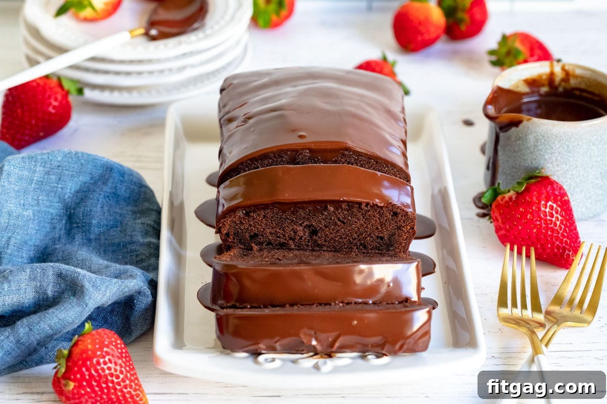 A beautifully baked chocolate pound cake loaf with three inviting slices neatly cut and arranged on a elegant white serving tray, accented with golden forks and a scattering of fresh, vibrant strawberries, creating a perfect dessert presentation.