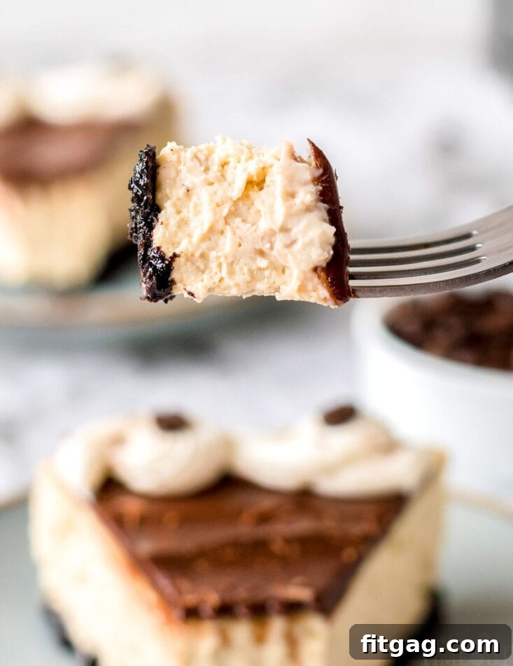 A fork taking a bite out of a slice of espresso cheesecake, showing the layers of crust, espresso filling, and ganache with frosting.