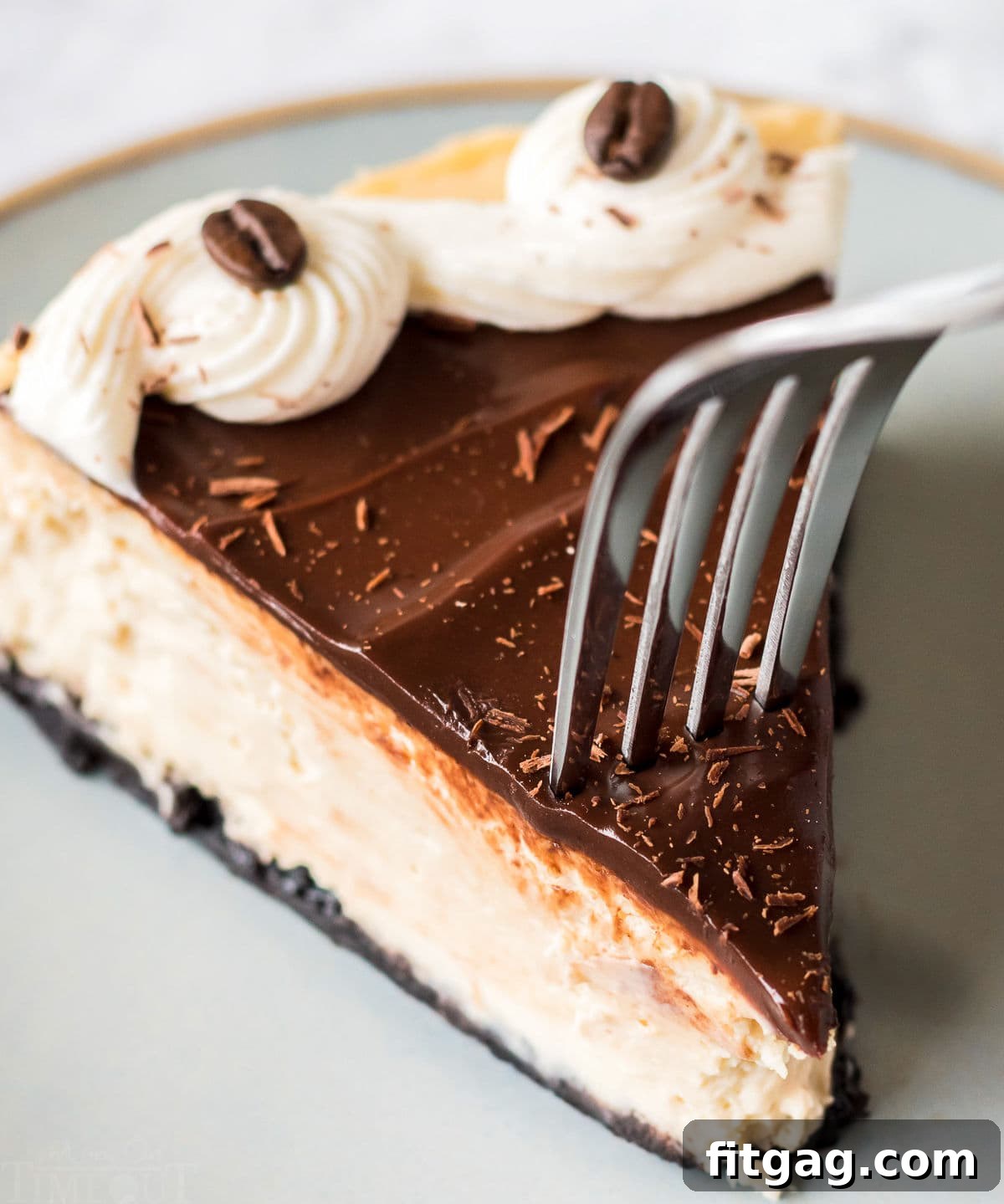 A fork piercing into a slice of espresso cheesecake, highlighting its creamy texture and the layers of crust and topping.