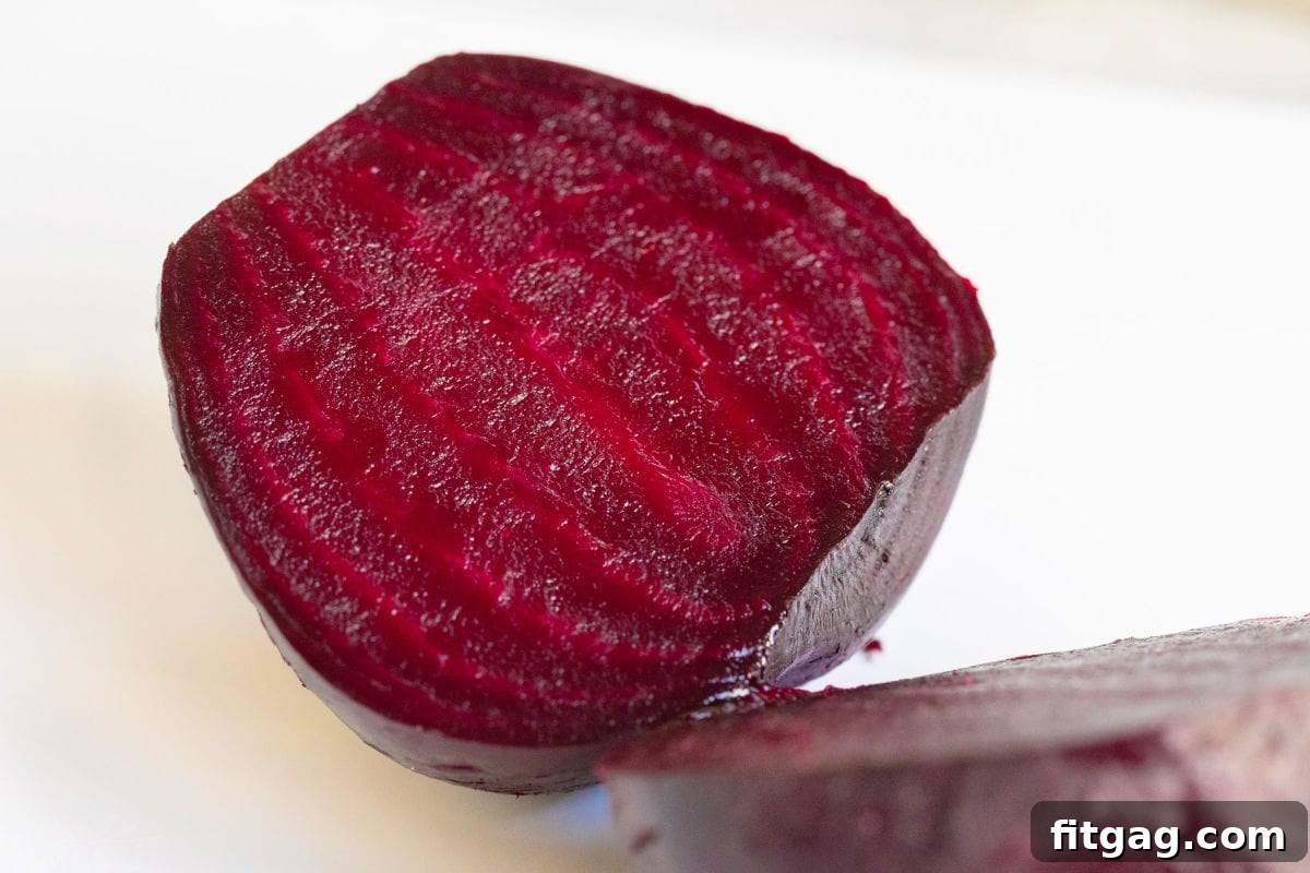 Effortlessly Delicious Roasted Beets 3 roasted beet cut in half on white board.