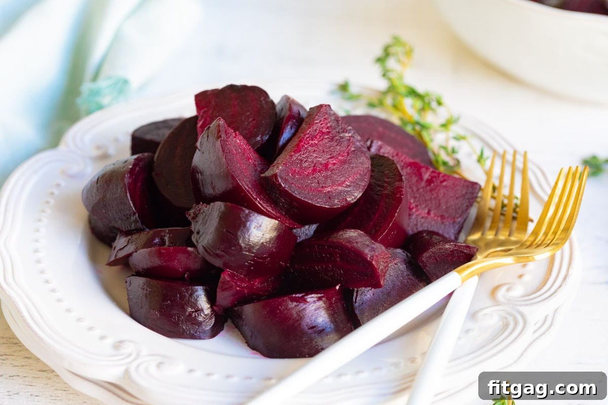 Effortlessly Delicious Roasted Beets 4 white plate with roasted beets and a couple of gold forks.