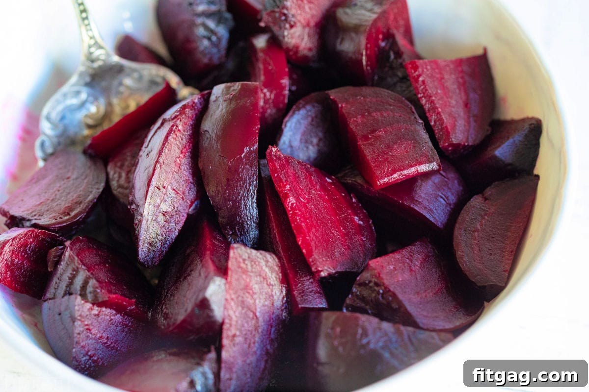 Effortlessly Delicious Roasted Beets 6 beets that have been roasted and cut into small pieces in a large white bowl.