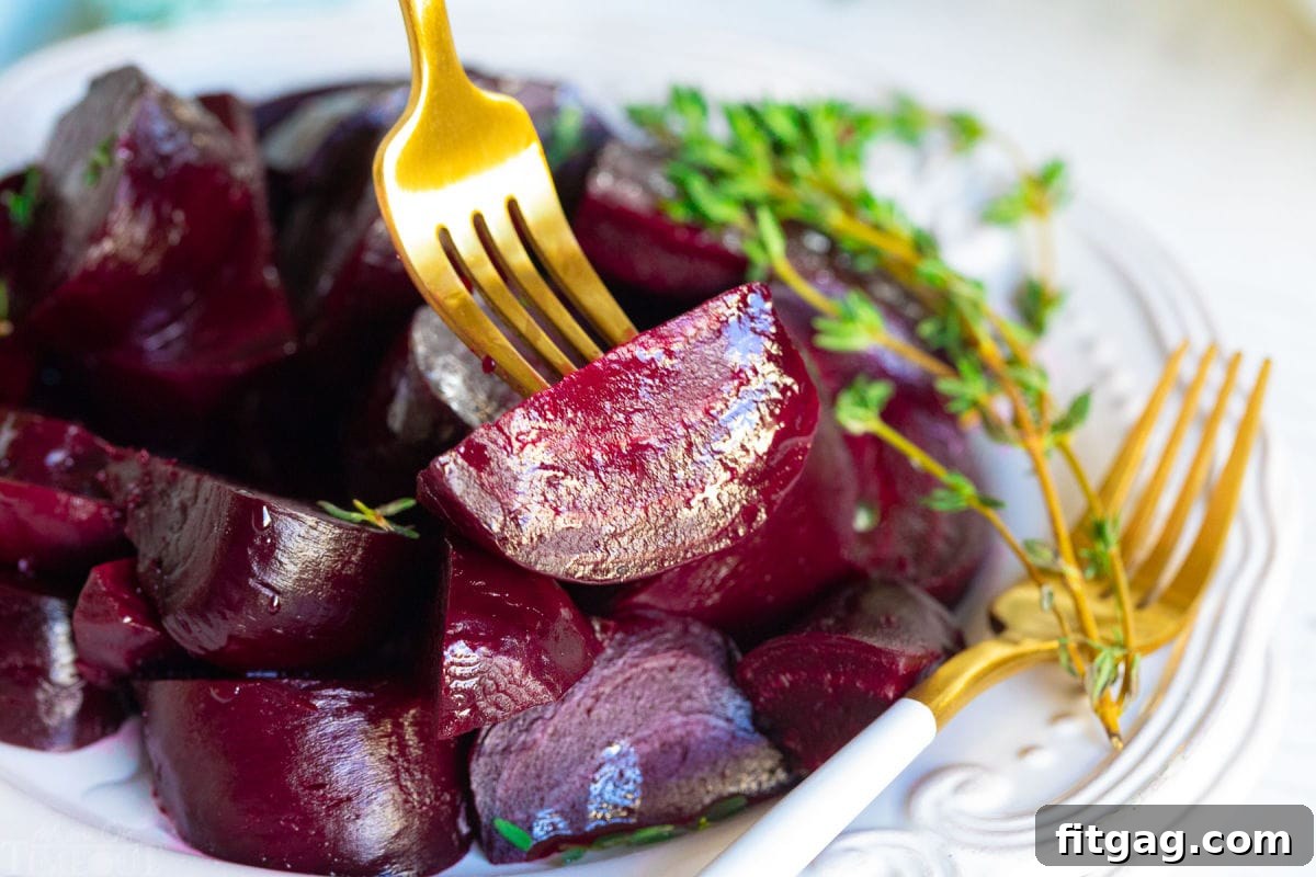 Effortlessly Delicious Roasted Beets 8 beet being picked up with gold fork.