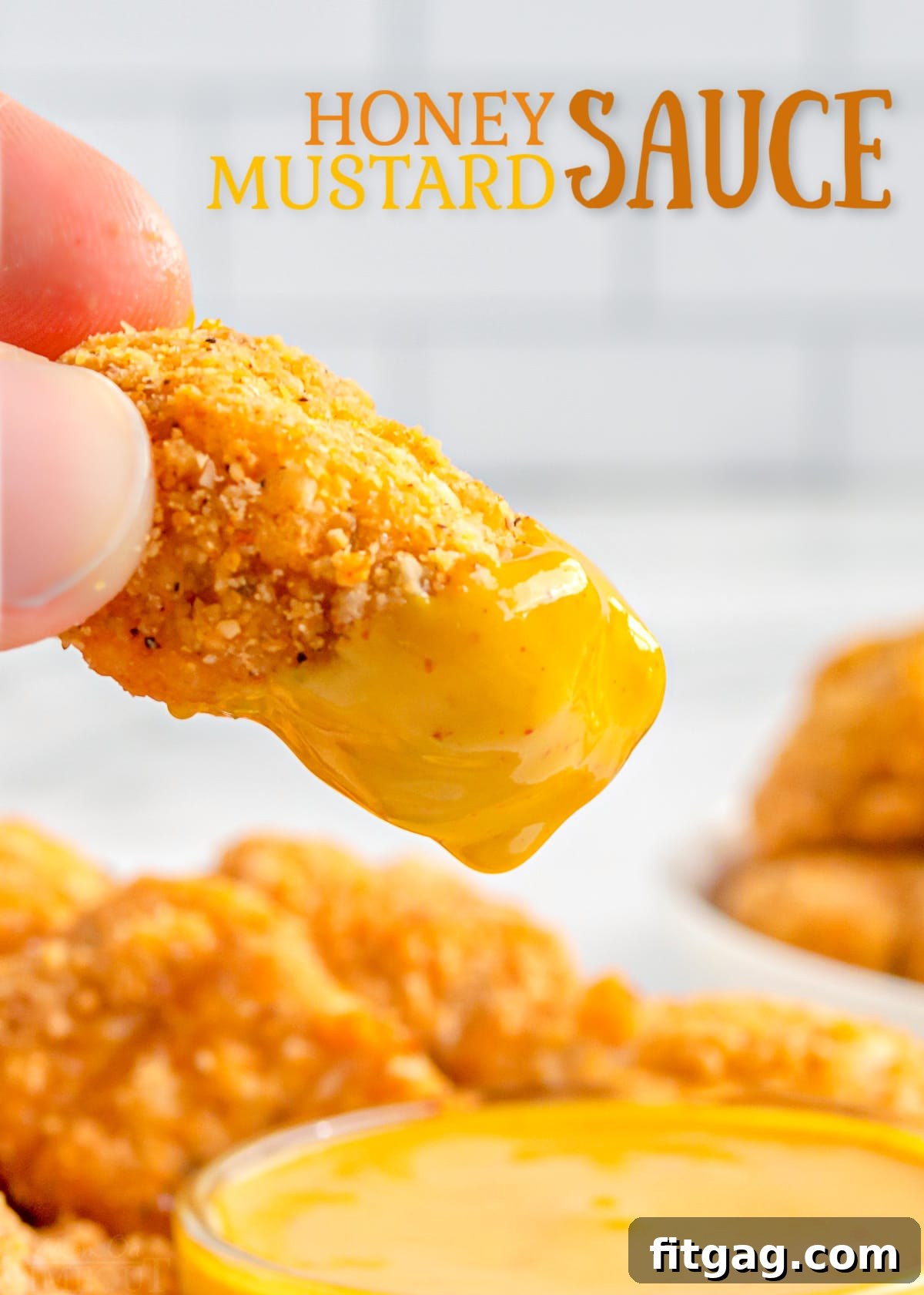 chicken nugget being dipped in honey mustard.