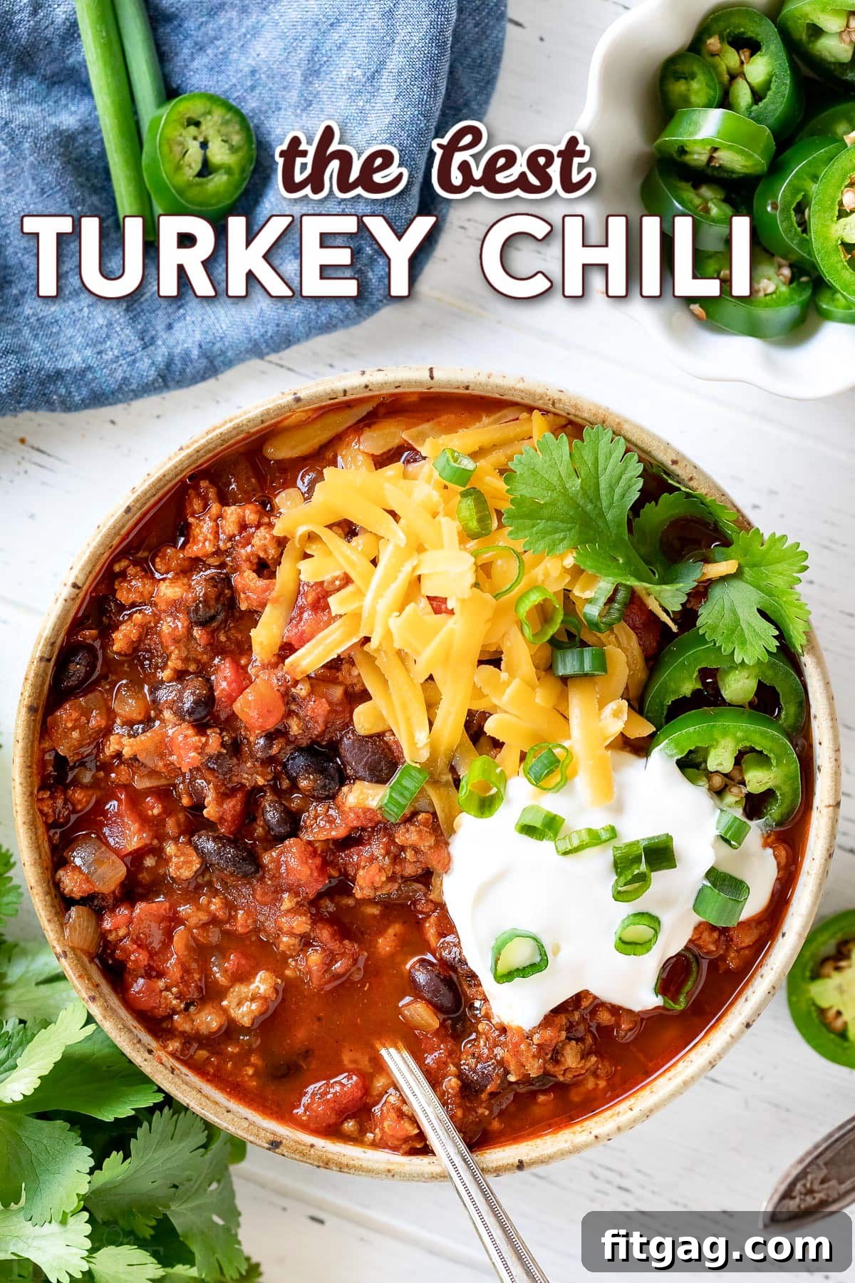 bowl of turkey chili with cheese sour cream and cilantro on top with title overlay.