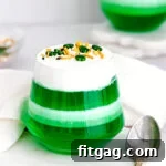 Layered green and white jello cups on a marble surface.