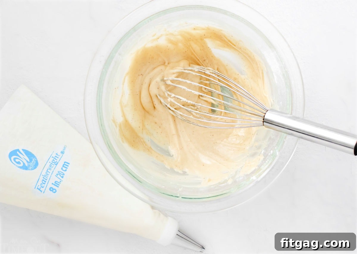 irish cream filling in glass bowl with whisk.