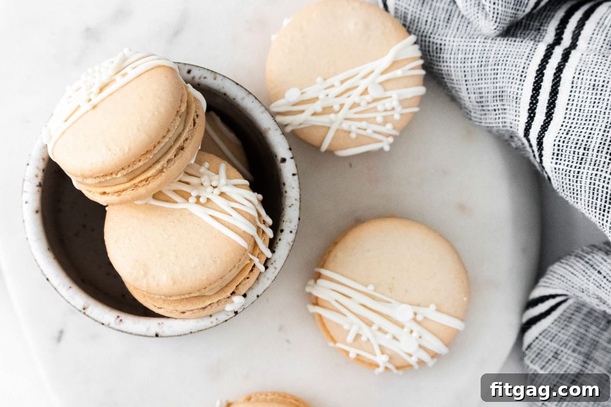 top down look at macarons decorated with white chocolate.