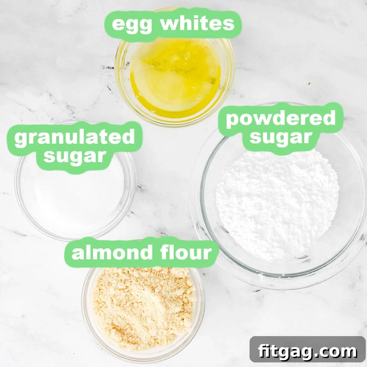 Macaron ingredients measured into small glass bowls.