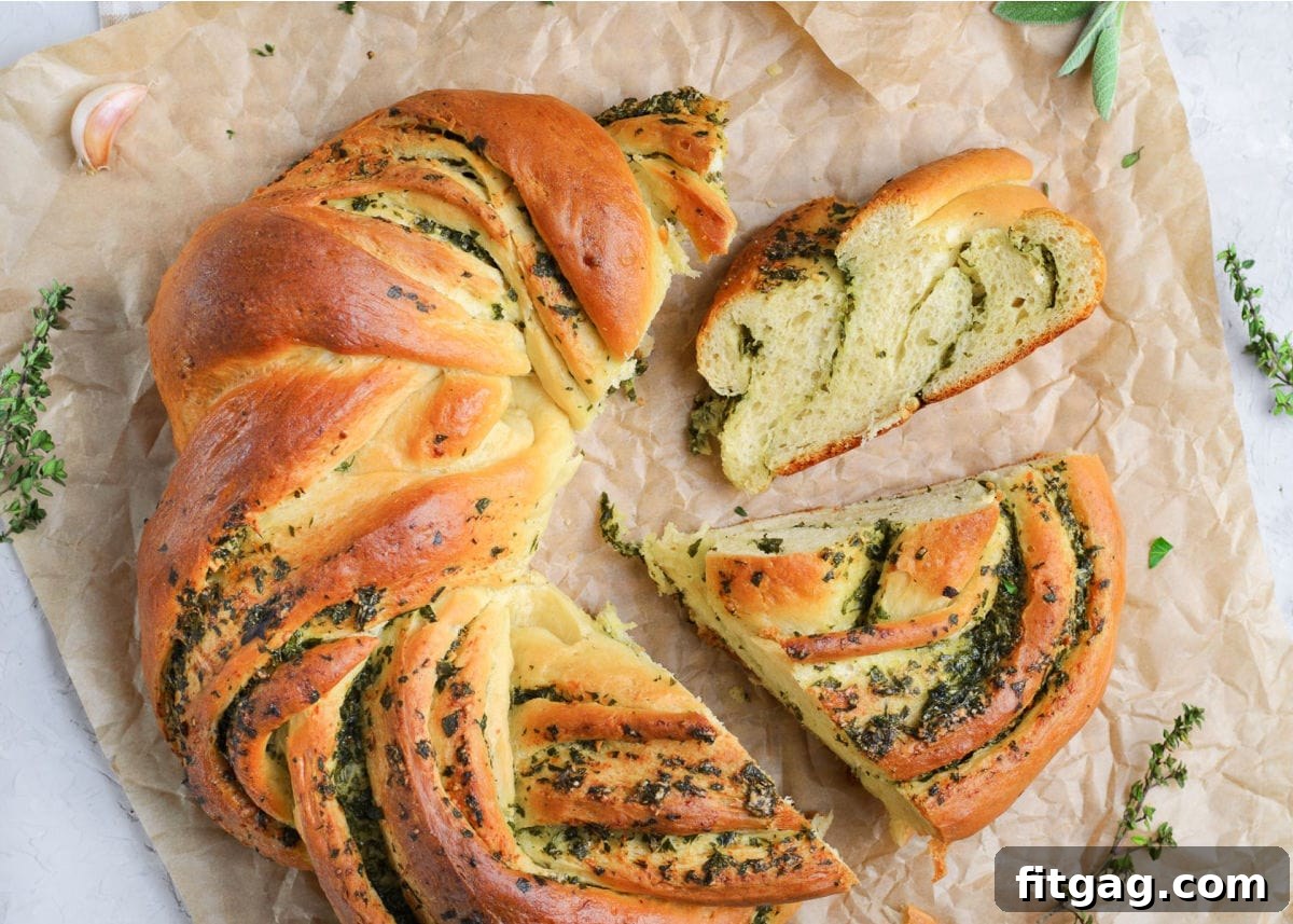 A top-down view of a beautifully baked Garlic Herb Bread Wreath, with two pieces sliced, ready for serving.