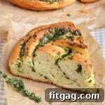 piece of garlic herb bread on brown parchment paper.