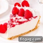 piece of cheesecake on plate garnished with fresh raspberries.