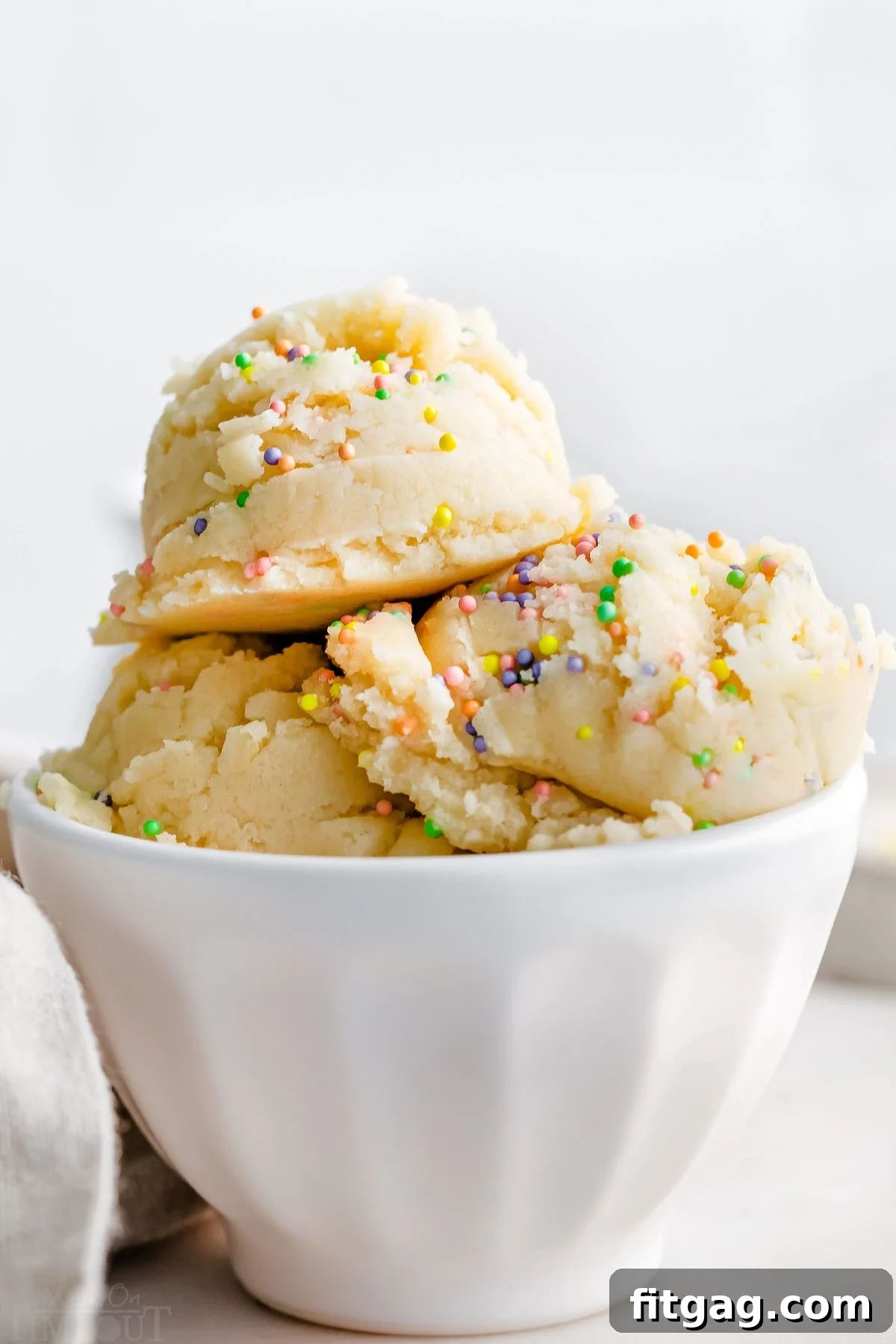 No-Bake Sugar Cookie Bliss 4 three scoops of cookie dough in white ice cream cup topped with sprinkles.