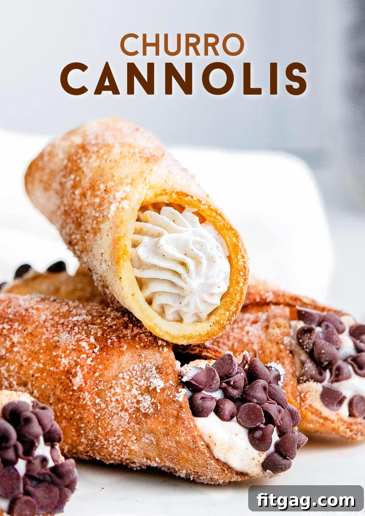 Three cannolis sitting on a white plate with cannoli filling and chocolate chips.