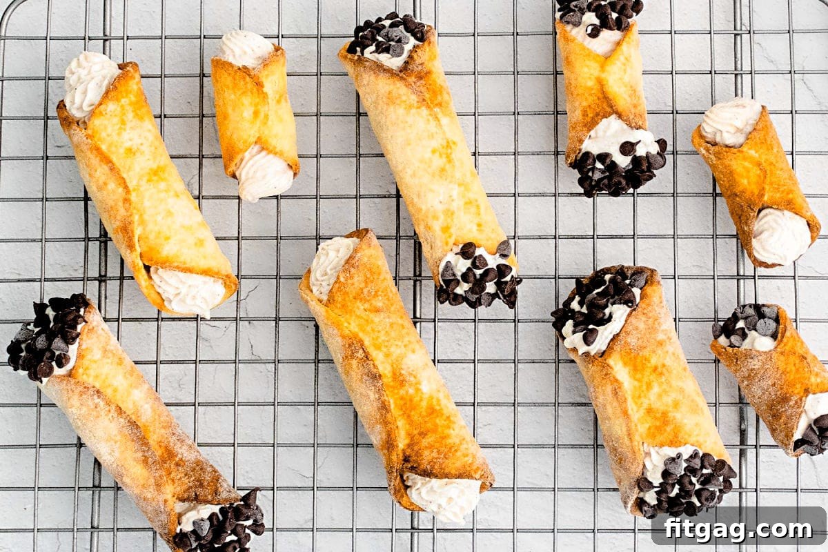 Filled cannolis on a metal rack ready to eat.