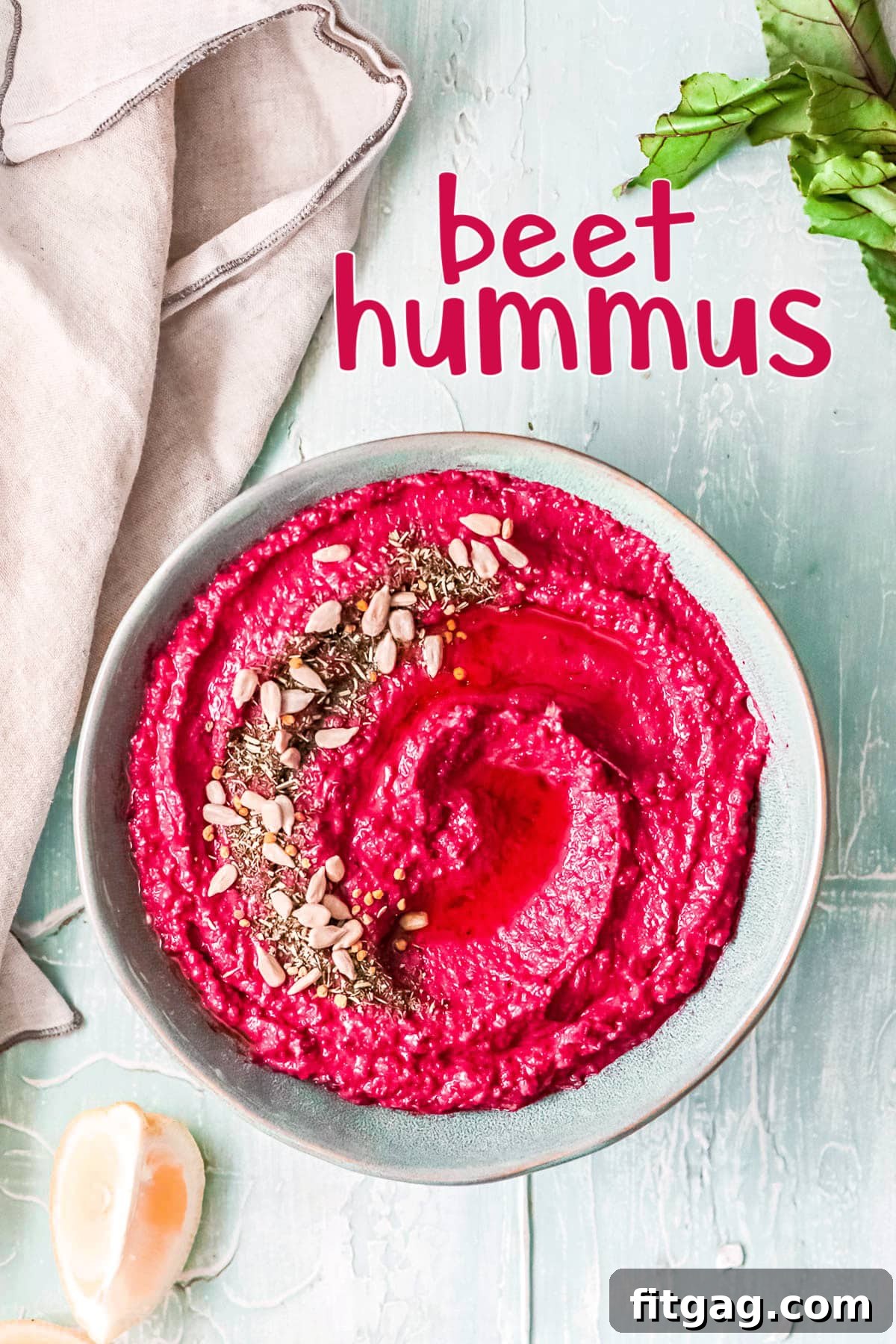 Vibrant Beet Hummus: Your Everyday Delight 2 Beet hummus served in a light blue bowl, perfectly garnished with a swirl of olive oil and a sprinkle of fresh herbs and seeds. A beige napkin rests elegantly to the side, highlighting the dish's vibrant color.