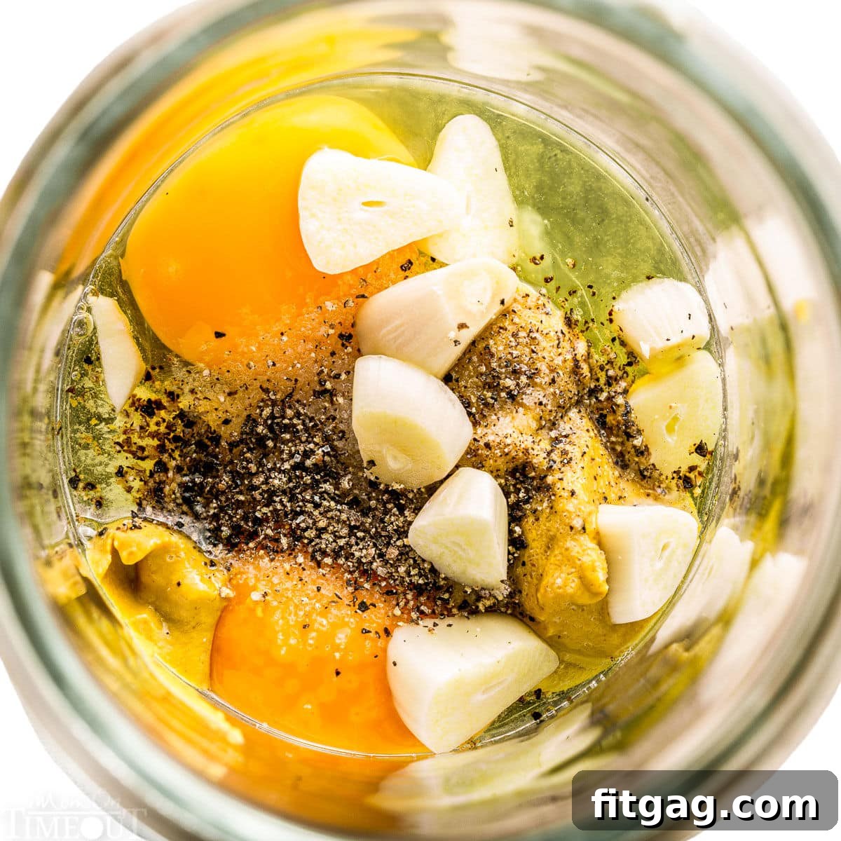 All aioli ingredients combined in a glass jar, ready for blending.