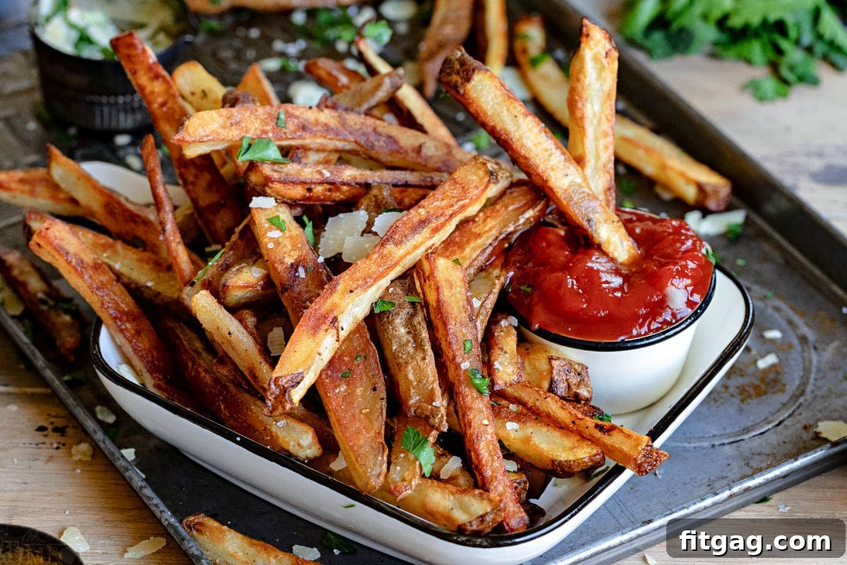 crispy oven fries sitting on white plate with small container of ketchup.